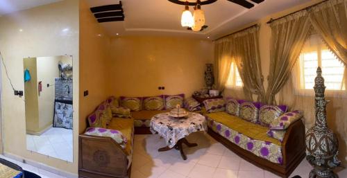 uma sala de estar com um sofá e uma mesa em Appartement marocain proche de la mer à Sidi Bouzid em Safi