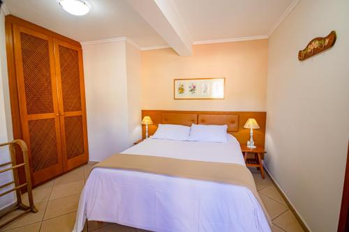 a bedroom with a white bed in a room at Pousada Alemã in Santo Antônio do Pinhal