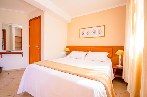 a bedroom with a large white bed in a room at Pousada Alemã in Santo Antônio do Pinhal