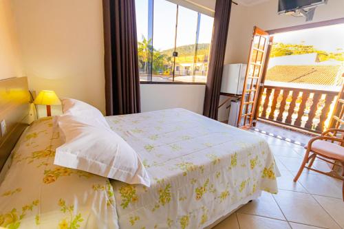a bedroom with a bed and a balcony at Pousada Alemã in Santo Antônio do Pinhal