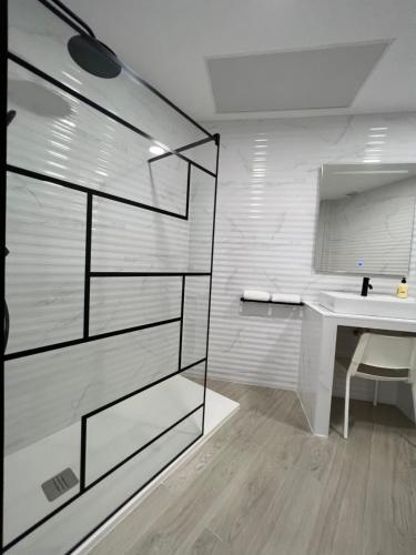 a bathroom with a sink and a mirror and a shower at APARTAMENTOS PLAYA VALENCIA in Valencia