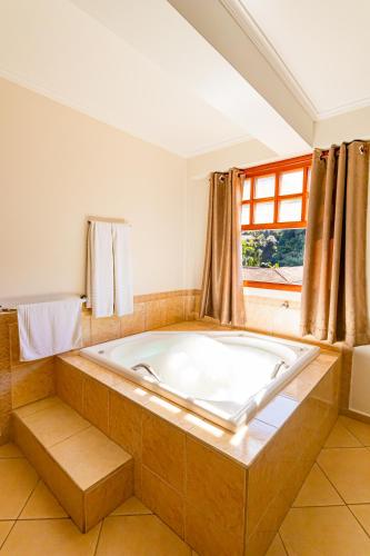 a large bath tub in a room with a window at Pousada Alemã in Santo Antônio do Pinhal