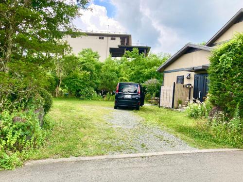 a car parked in a yard next to a house at 富士の樱House 宝栄 in Fujikawaguchiko
