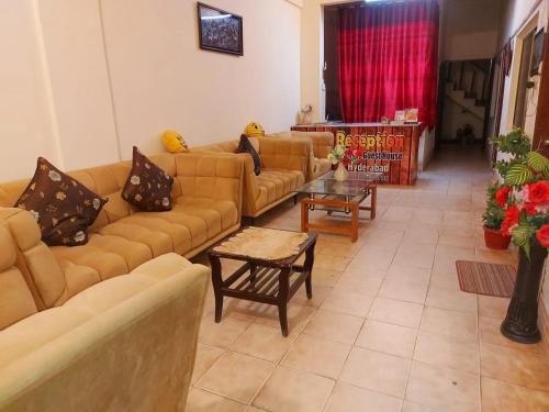 a living room with couches and a table at Embassy inn Guest House Hyderabad in Hyderabad