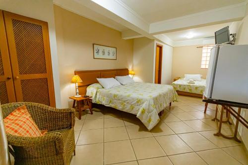 a hotel room with a bed and a tv at Pousada Alemã in Santo Antônio do Pinhal