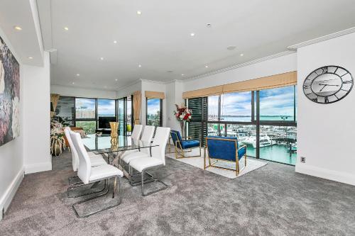 a dining room with a table and chairs and a clock at Waterfront Wonder + Cp! in Auckland