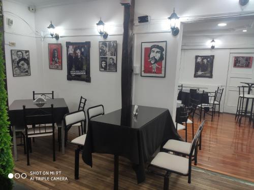 a dining room with tables and chairs and pictures on the walls at Hotel el Che No apto para corruptos in Azogues