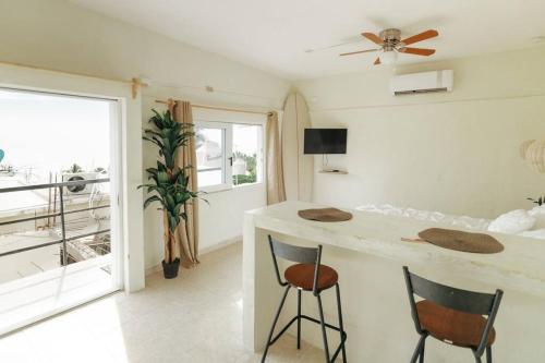 a kitchen with a counter and two chairs in a room at Estancias playa Costa Azul Surf in San José del Cabo