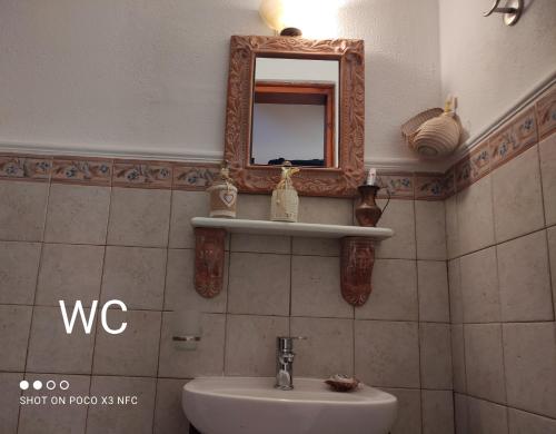 a bathroom with a sink and a mirror on the wall at MESONISI maisonette in Afissos