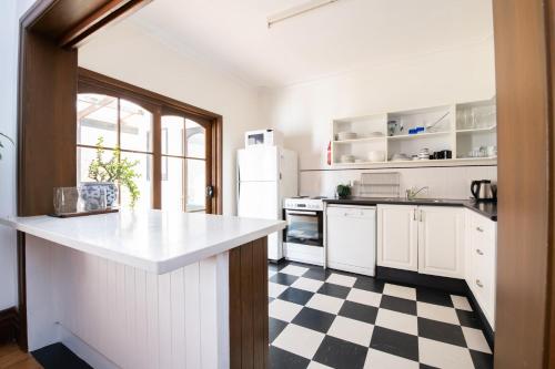 una cucina con pavimento a scacchi in bianco e nero di Parkview Cottage - Antique Elegance a Orange