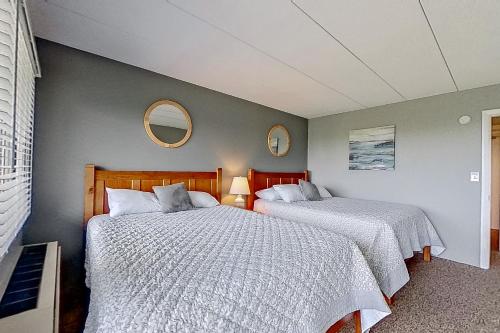 um quarto com 2 camas e um espelho na parede em Cedar Lodge Condo, Unit 205 em Laconia