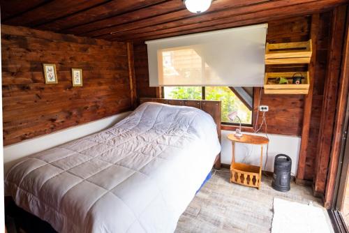 a bedroom with a bed in a log cabin at Casa#7 in San José
