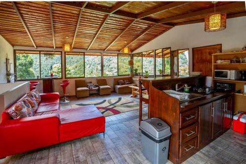 a living room with a red couch and a kitchen at Casa#7 in San José