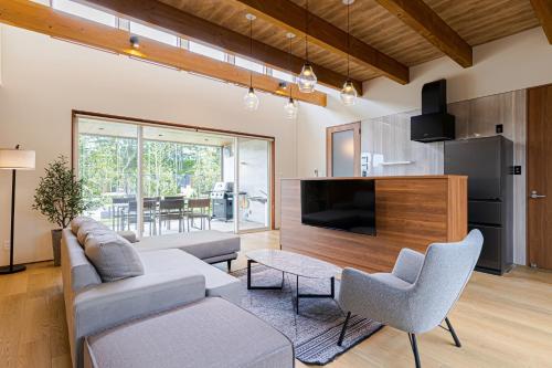 a living room with a couch and a tv at AWAUMI　富士・河口湖リゾート in Fujikawaguchiko