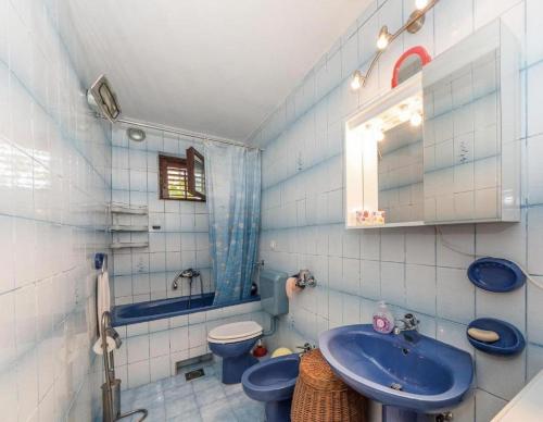 a bathroom with a blue sink and a toilet at Apartments by the sea Podstrana, Split - 15963 in Podstrana
