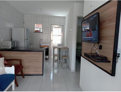 eine Küche mit einem TV und eine Küche mit einer Theke in der Unterkunft Cantinho da Felicidade in Trairi