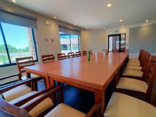 a conference room with a large wooden table and chairs at Hotel La Querencia in Río Verde
