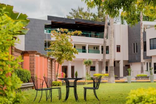 a table and chairs in front of a building at Hotel La Querencia in Río Verde