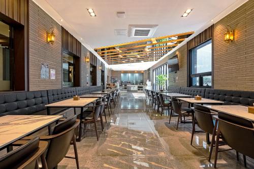 浦項的住宿－Pohang A1Hotel Haedo，用餐室设有桌椅和窗户。