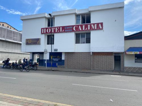 um edifício hospitalar com pessoas em motocicletas na rua em Hotel calima em Tuluá