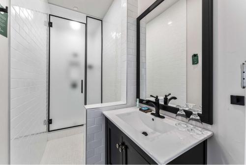 a white bathroom with a sink and a shower at The Inn on Officers' Garden in Calgary