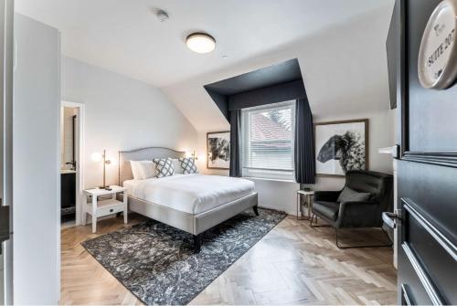 a bedroom with a bed and a chair at The Inn on Officers' Garden in Calgary