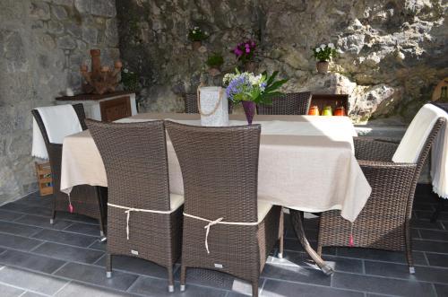 a table with wicker chairs and a table with flowers on it at Casa Maru in Camarmeña