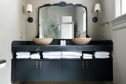 a bathroom with two sinks and a large mirror at The Juliette - Luxury Historic Residence in Charleston