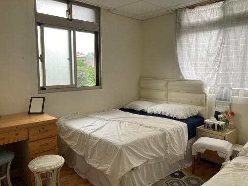 a bedroom with a bed and a desk and a window at 蟲鳴鳥叫 in Hsiao-p'ing-ting