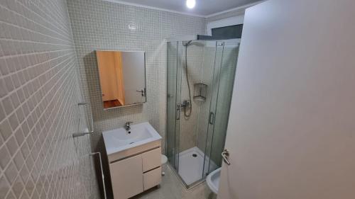 uma casa de banho com um lavatório, um chuveiro e um WC. em Casa Sonho Azores - AL 1449 em Ponta Delgada