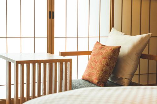 two pillows sitting on a chair in a room at KAYA Kyoto Nijo Castle, BW Signature Collection by Best Western in Kyoto