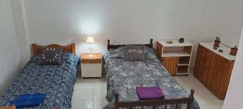 1 dormitorio con 2 camas y mesa con mesita de noche en Monte Pissis ARG Departamento en Alquiler Temporario en San Fernando del Valle de Catamarca