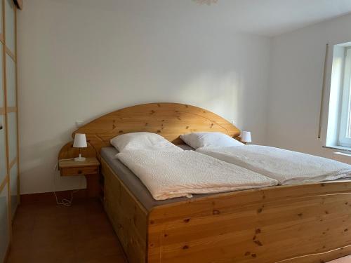 ケーニヒスヴィンターにあるBüchling FEWOの木製ヘッドボード付きのベッドルームのベッド1台