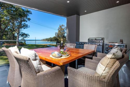 a dining room with a wooden table and chairs at Moona Sands in Huskisson