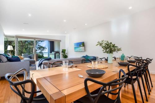 a dining room with a wooden table and chairs at Moona Sands in Huskisson
