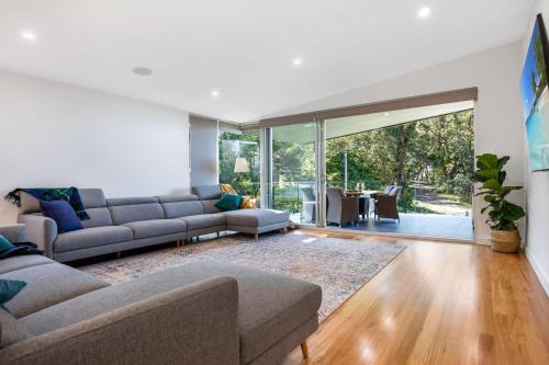 a living room with two couches and a large window at Moona Sands in Huskisson