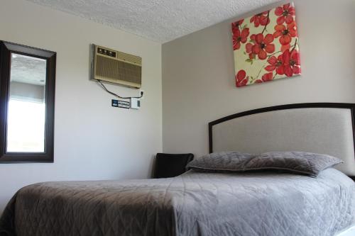 a bedroom with a bed and a window at Le Marigot in Vaudreuil-Dorion