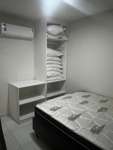 a small bedroom with a bed and a white closet at Porto de Galinhas - Apartamento Flat Sea Residence 304 in Porto De Galinhas
