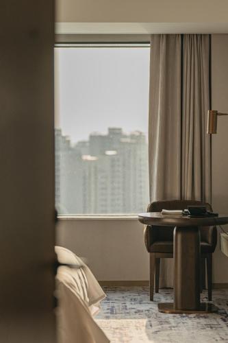 a room with a window and a table and a chair at Lotte Hotel World in Seoul