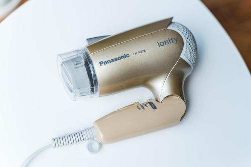 a hair drier sitting on a table with a brush at Flower Base Lily House in Fukuoka