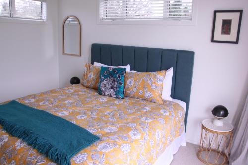 a bed with a blue headboard in a bedroom at Sublime Nooks in Havelock North