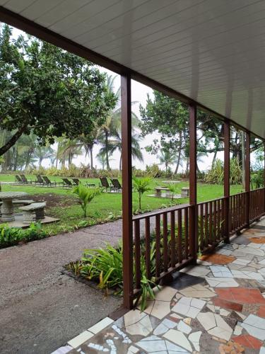 a covered porch with a view of a park at Hotel Tortuguero Beachfront in Tortuguero