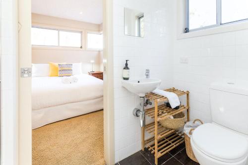 ein Bad mit einem Waschbecken, einem WC und einem Bett in der Unterkunft Springbank House in Jindy Andy