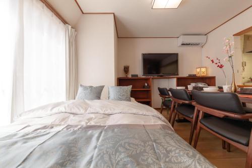 東京的住宿－Second kuwamura building，一间卧室配有一张床和一张桌子及椅子