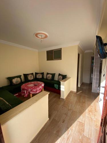 uma sala de estar com um sofá e uma mesa em Apartamento moulay bouslham em Riah