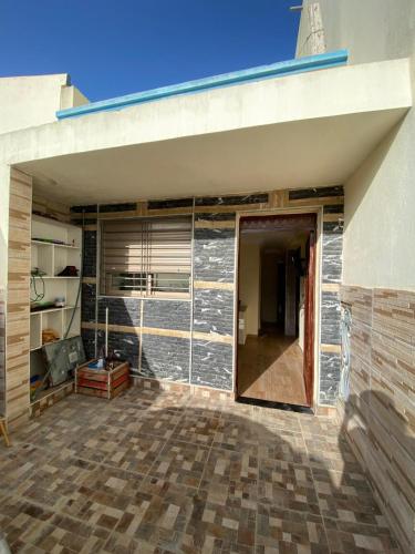 uma garagem com uma porta e uma parede de tijolos em Apartamento moulay bouslham em Riah