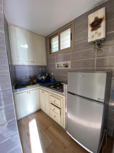 uma cozinha com armários brancos e um frigorífico em Apartamento moulay bouslham em Riah