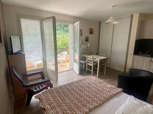 - une chambre avec un lit et une chambre avec une table dans l'établissement Studio ensoleillé avec balcon et parking - WiFi inclus - Centre-ville Amélie-les-Bains - FR-1-703-164, à Amélie-les-Bains-Palalda