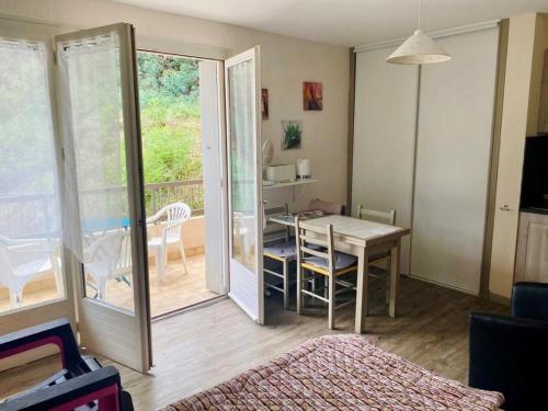 un salon avec une table et une salle à manger dans l'établissement Studio ensoleillé avec balcon et parking - WiFi inclus - Centre-ville Amélie-les-Bains - FR-1-703-164, à Amélie-les-Bains-Palalda