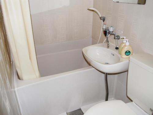 a white bathroom with a sink and a toilet at Hotel Cotton 100% in Nara